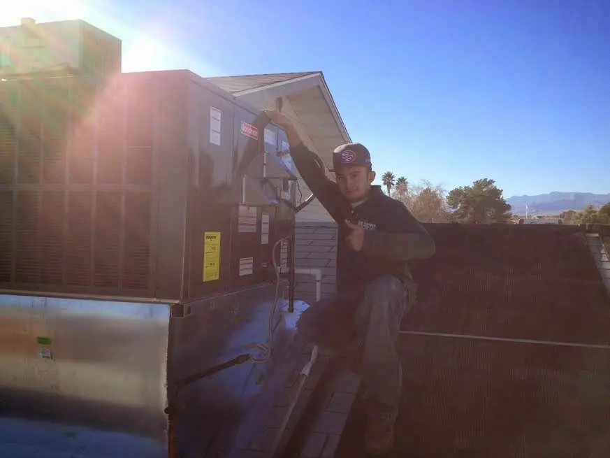 HVAC technician performing HVAC Inspection on a rooftop unit in Demopolis